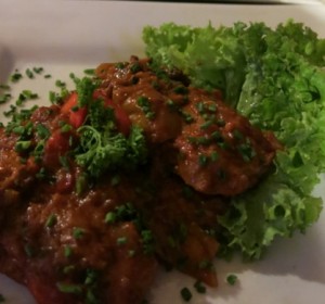 Sausages in dark beer sauce with hot peppers