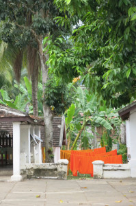Saffron-colored monks' robes hung out to dry in the courtyard of a wat.